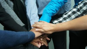 A group of people with hands stacked in unity